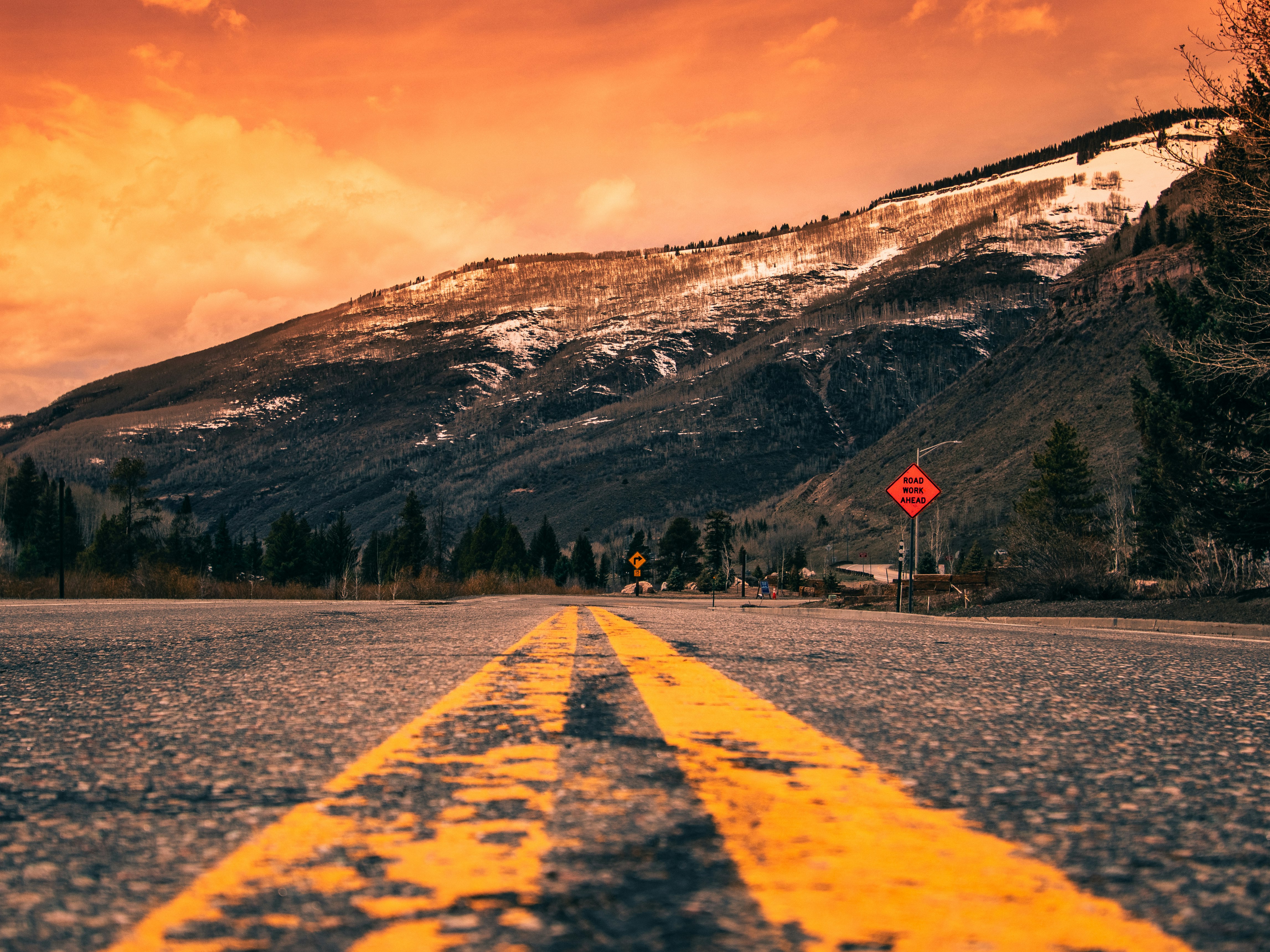 gray concrete road near mountain during daytime